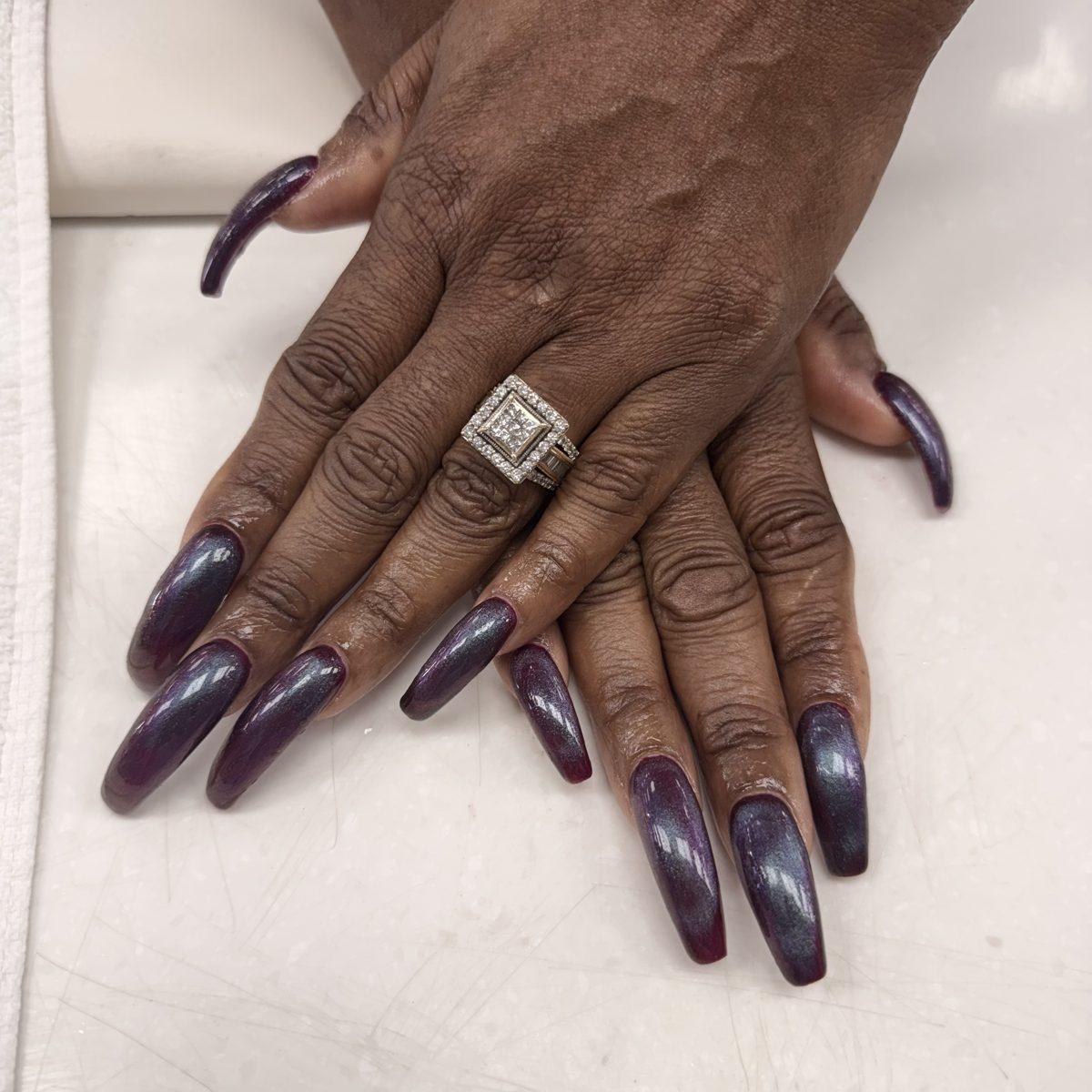 Extra-long coffin nails in a deep plum cat-eye gel with a blue shimmer